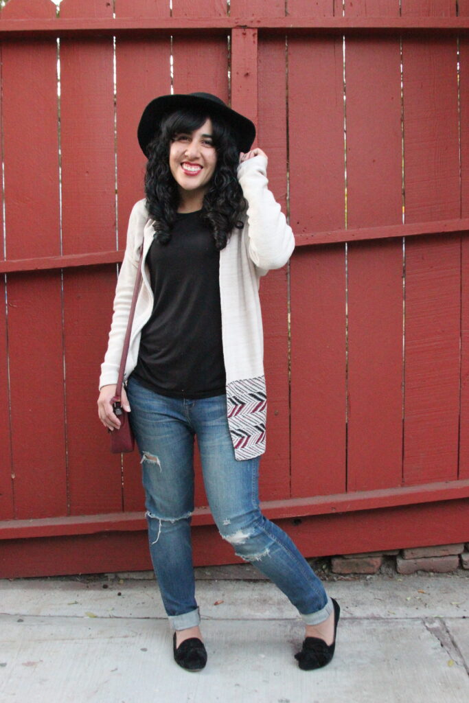 Brandy Outfit Post featuring a Tan Cardigan, Wool Hat, Black Shirt, Ripped Blue Jeans, and Black Tassel Loafers